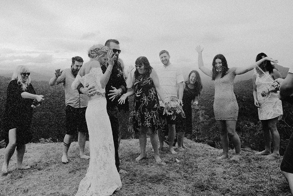 champagne sprays in celbration at the top of a mountain  in the jungle at this belize adventure wedding