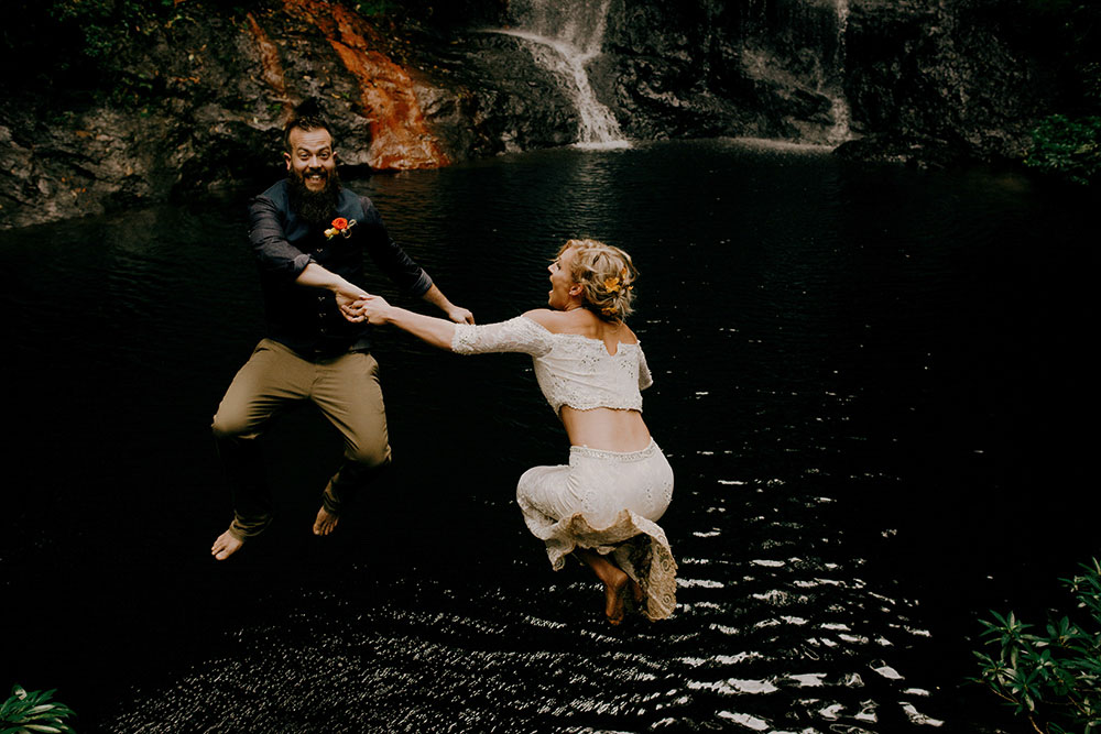 celebrating being married by jumpng in the water in the jungle at this belize adventure wedding