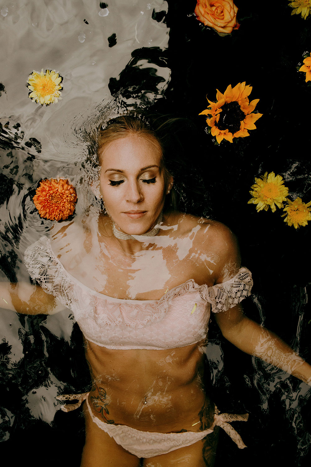 gorgeous bride floats in the clear waters below a waterfall at her wedding  in the jungle at this belize wedding