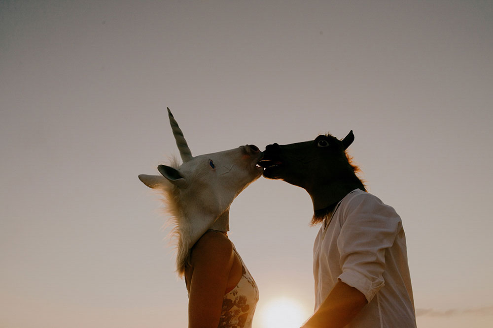 horse maskes on couple kisses at  belize wedding