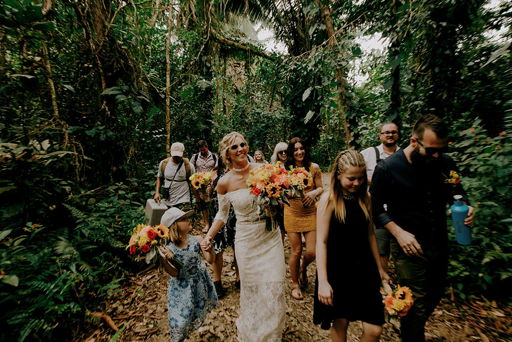 wedding group walks up the mountain in the jungle at this belize wedding