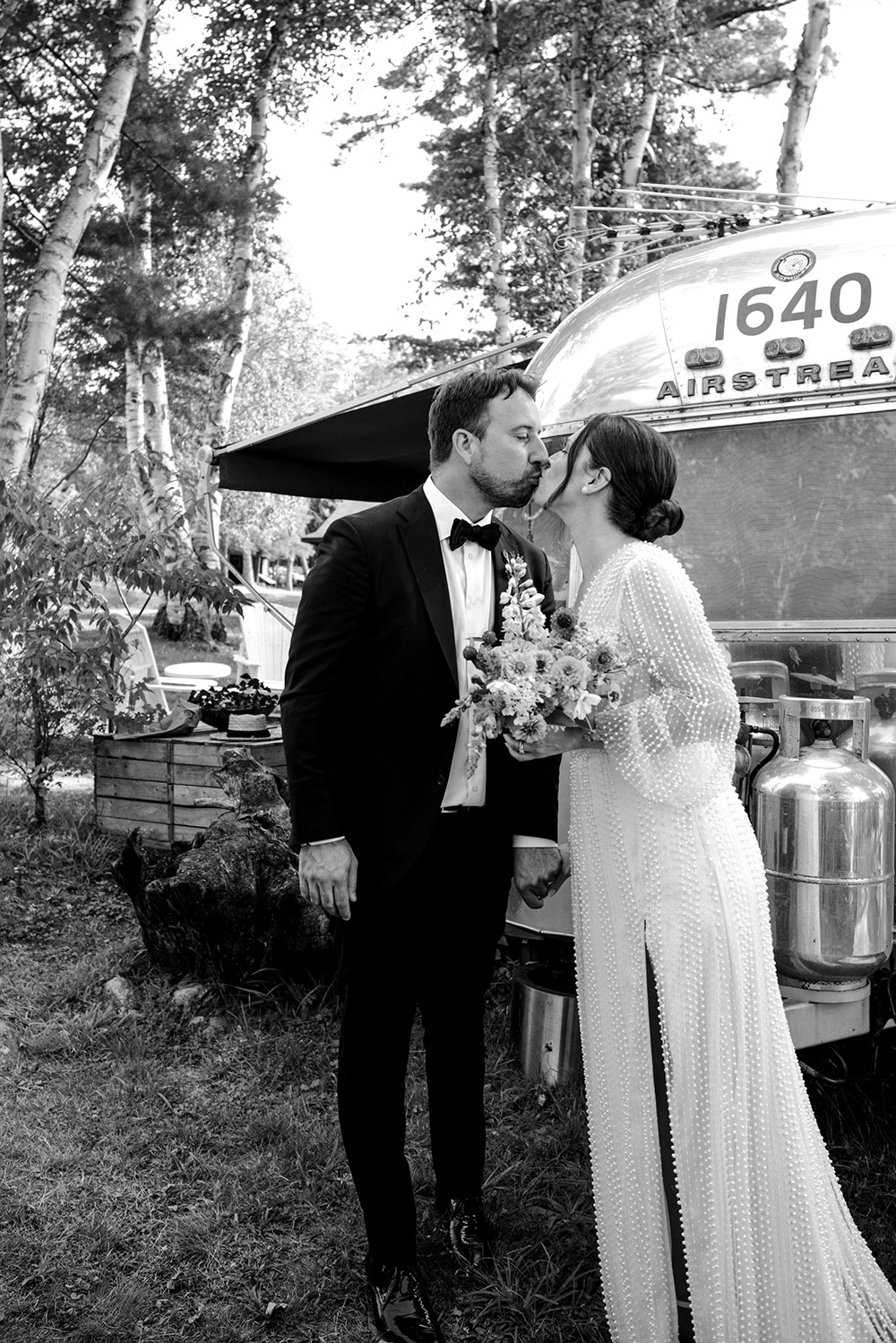 couple share a kiss in front of an air stream at their Northridge Inn Wedding