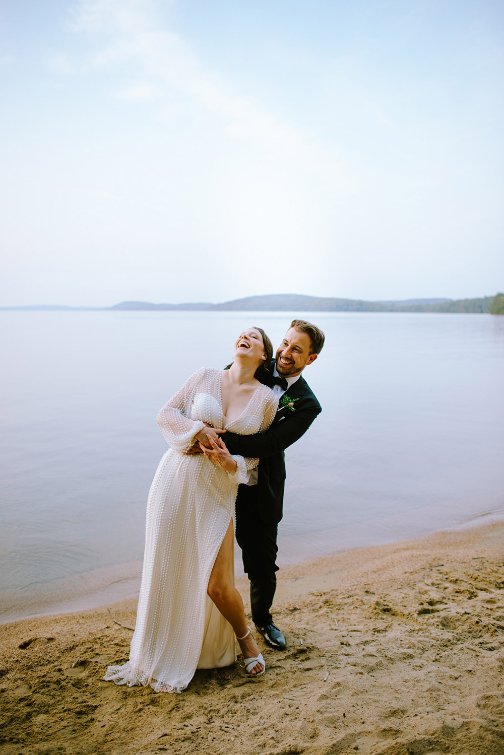 a Big laugh with bride and groom on the sandy beach at their Northridge Inn Wedding during sunset 