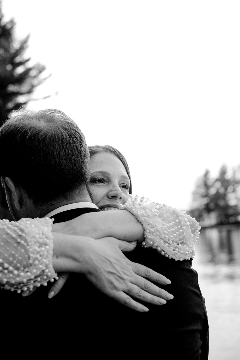 a close up of the bride as she embraces her husband on the beach at their Northridge Inn Wedding