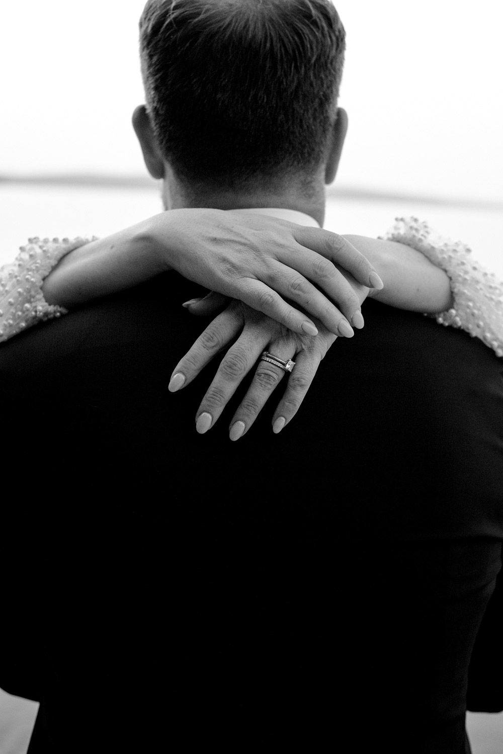 Newlewds embrace and new rings are featured in the black and white photo taken at their Northridge Inn Wedding in Muskoka Ontario