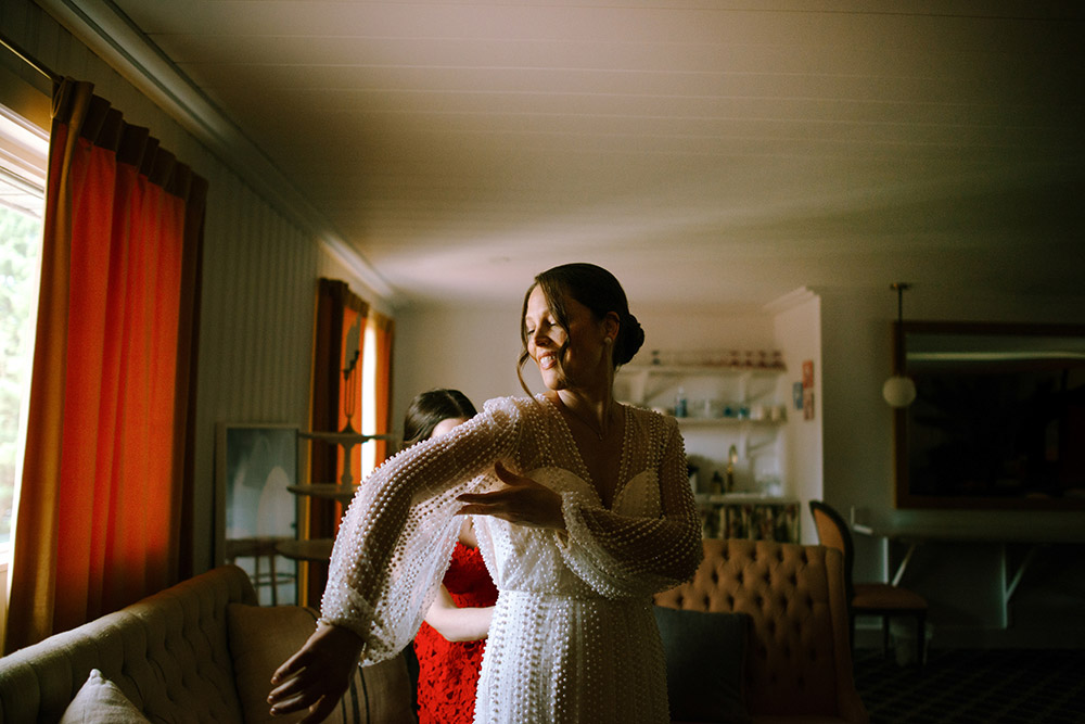 Bride adjusts her gown moments before saying I do at the Northridge Inn in Muskoka