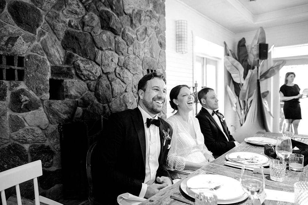 Couple laugh while enjoying speeches at their Northridge Inn Wedding in Muskoka