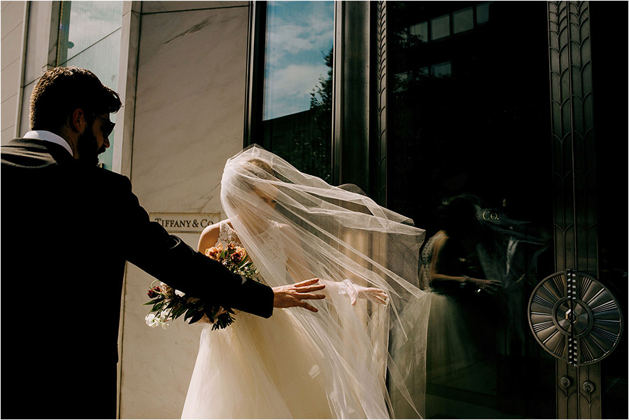 Toronto Wedding photography of a Wedding couple walking around downtown Toronto passed a Tiffany's Store front just outside of the ROM