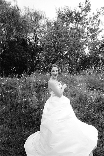 Ontario Wedding Photography of a bride laughing to herself in the nature filled backdrop just outside her Ontario Wedding Venue