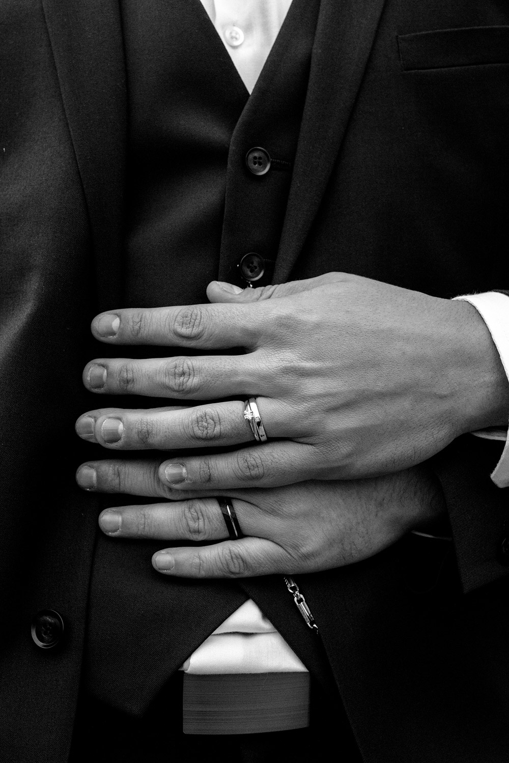 a close up of husbands hands showcasing their wedding bands at this science north wedding