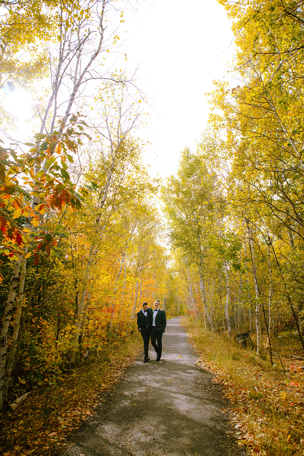 grooms walk together on a fall day before they're science north wedding