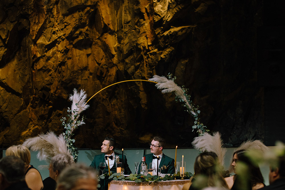 grooms enjoy the speeches from their head table at this this science north wedding