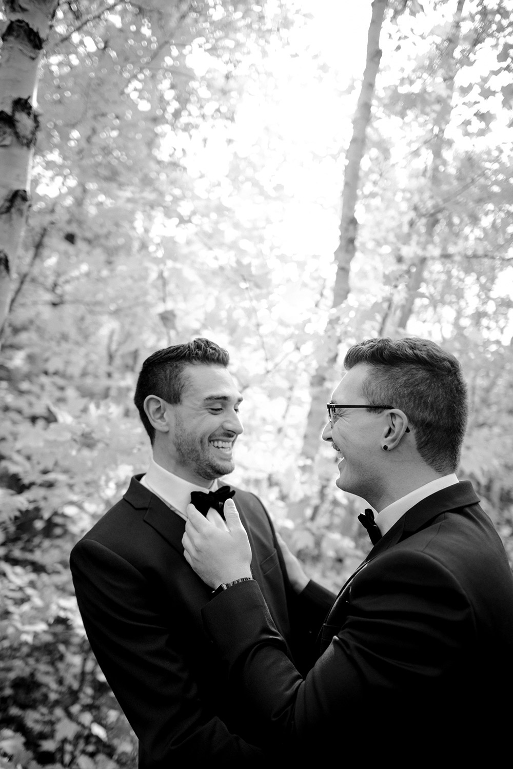 grooms laugh together during a private moment before their science north wedding