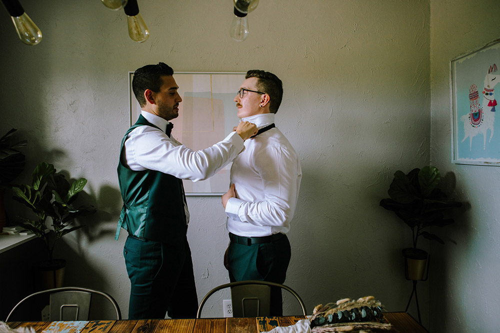 groom fixes his grooms bow tie before this science north wedding