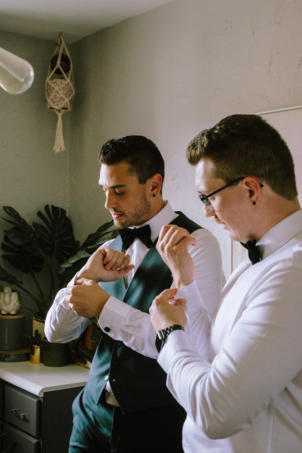 both grooms pictured fixing their cuff links at this science north wedding