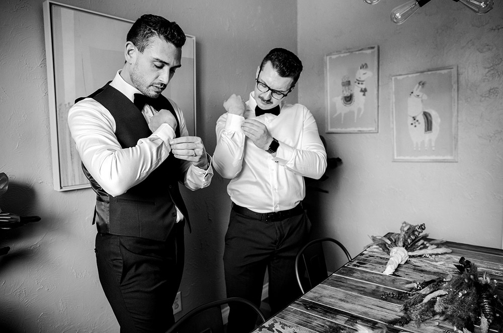 both grooms pictured fixing their cuff links at this science north wedding