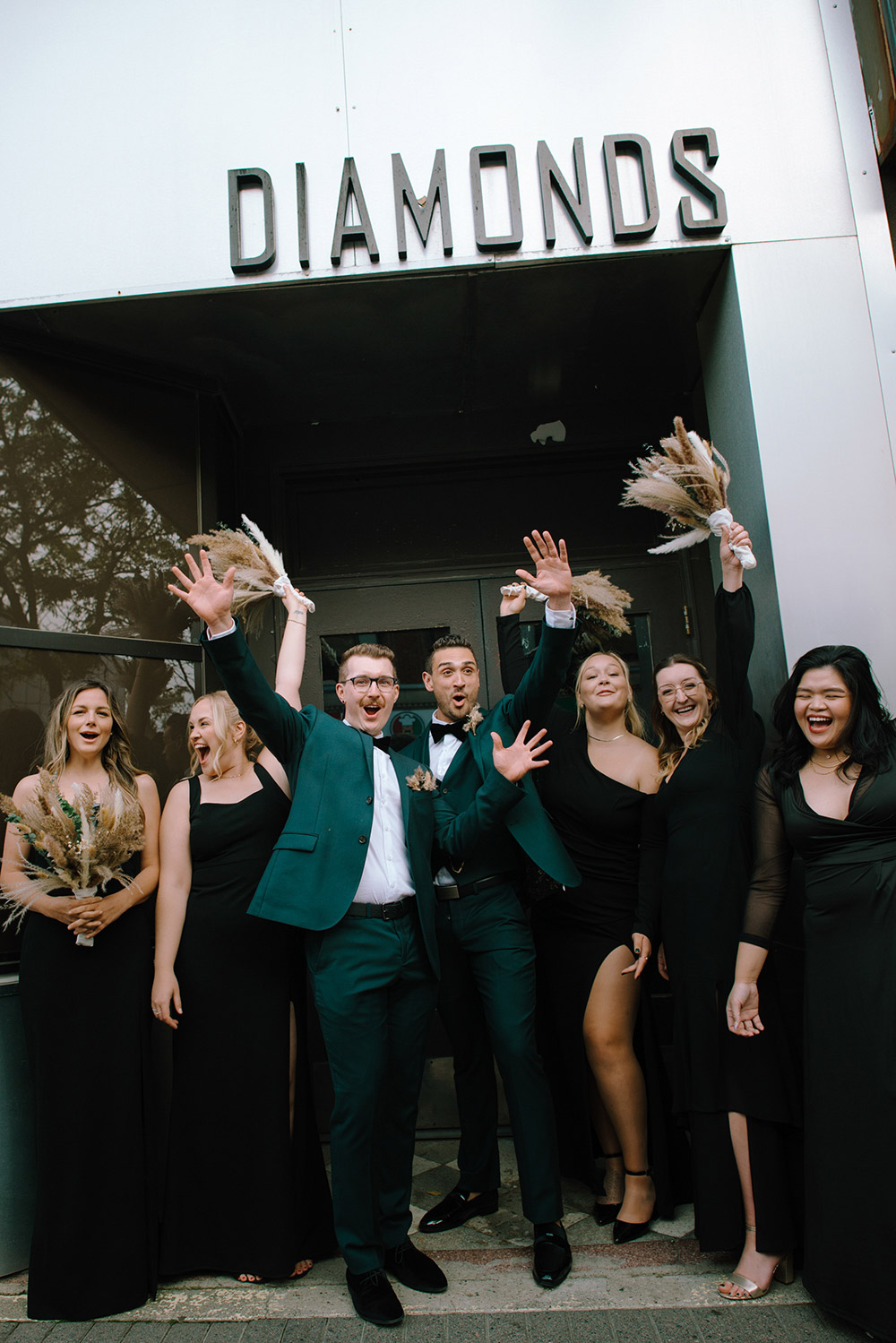 wedding party pose under a sign that says diamonds at this science north wedding in sudbury