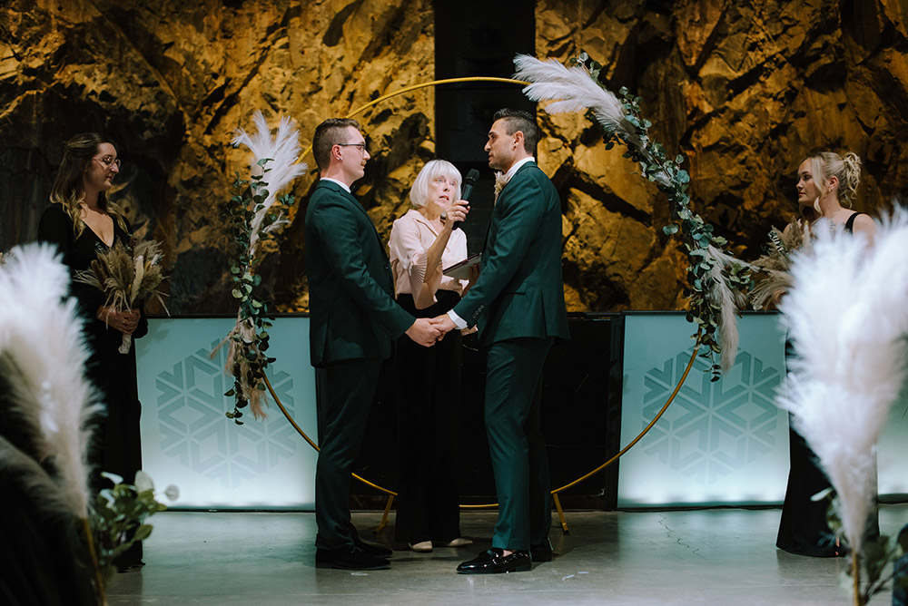 grooms say their vows in to the mic at their science north wedding