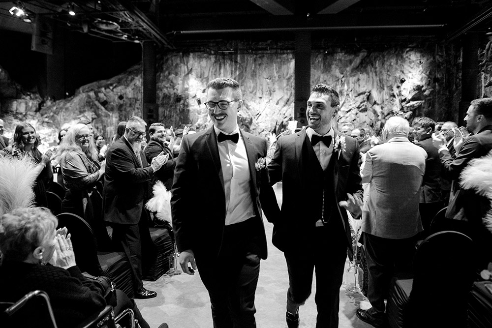 grooms walk down the aisle as husband and husband at this science north wedding