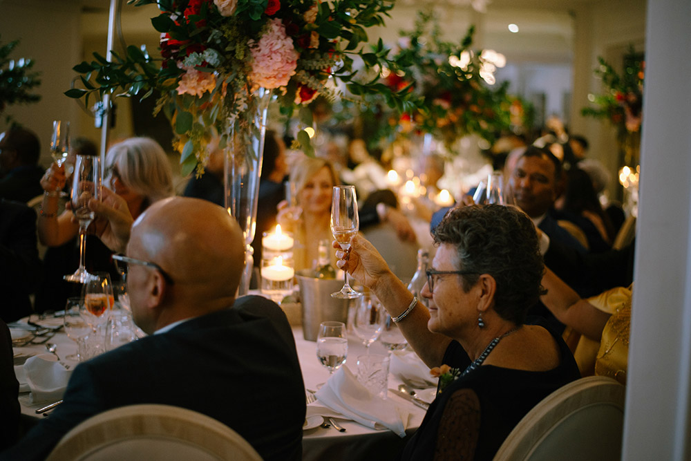 a woman raises her glass during a toast at The Doctor's House Wedding