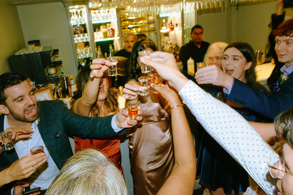 a group of guests cheers for a shot The Doctor's House Wedding