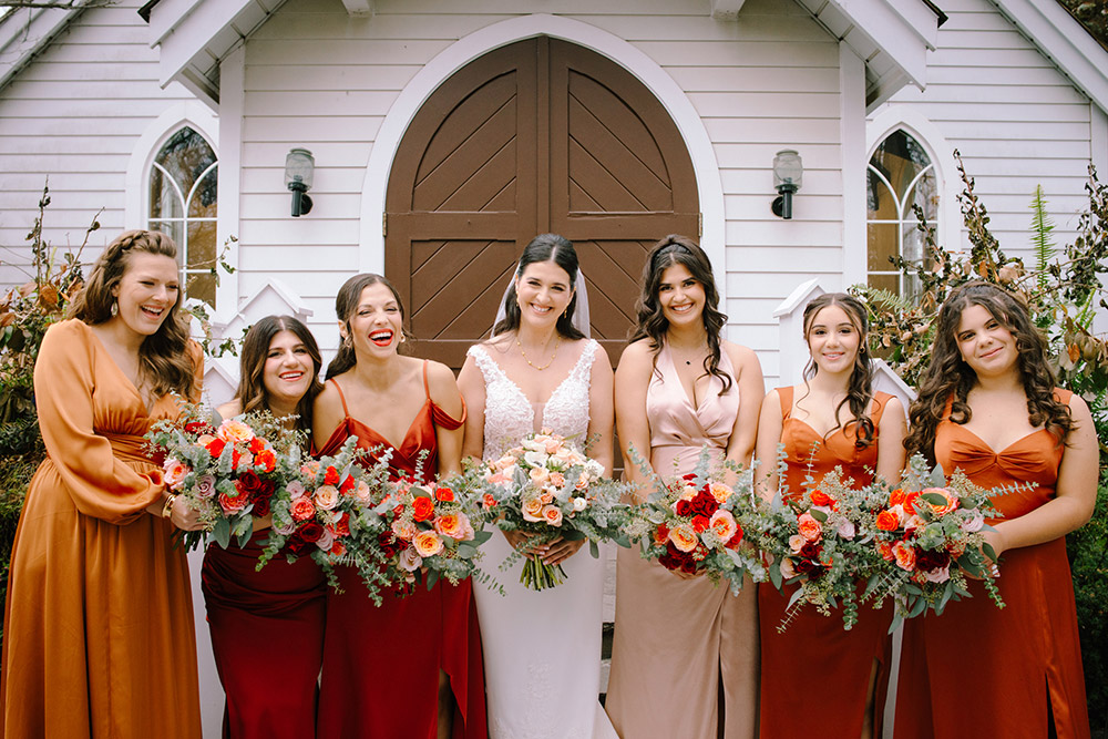 the bridesmaids pose with flowers in hand at The Doctor's House Wedding