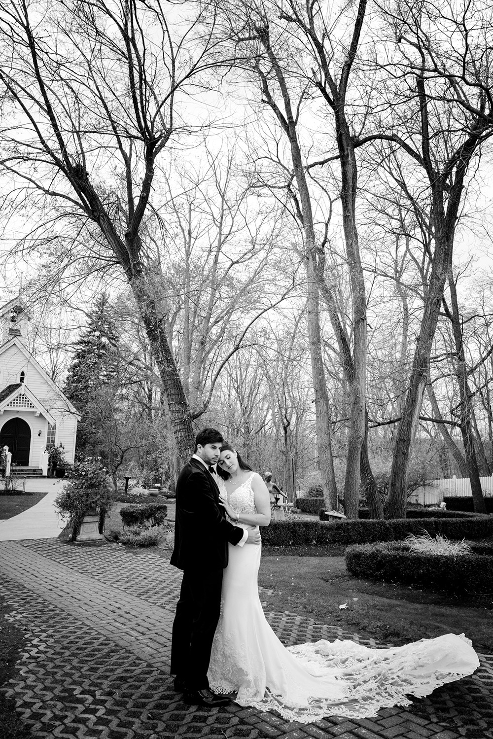 bride and groom pose for a photo in fron of the chapel at The Doctor's House Wedding