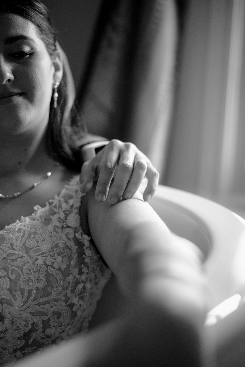 close up grooms hand on bride's shoulder