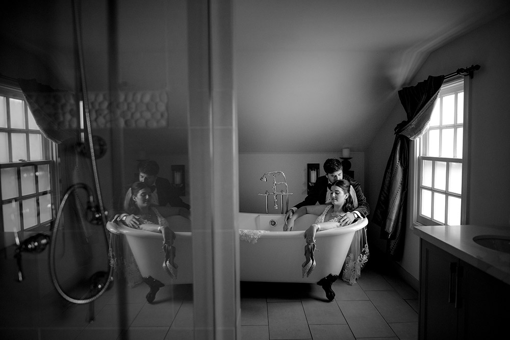 couple sits in clawfoot tub during wedding portraits at The Doctor's House Wedding