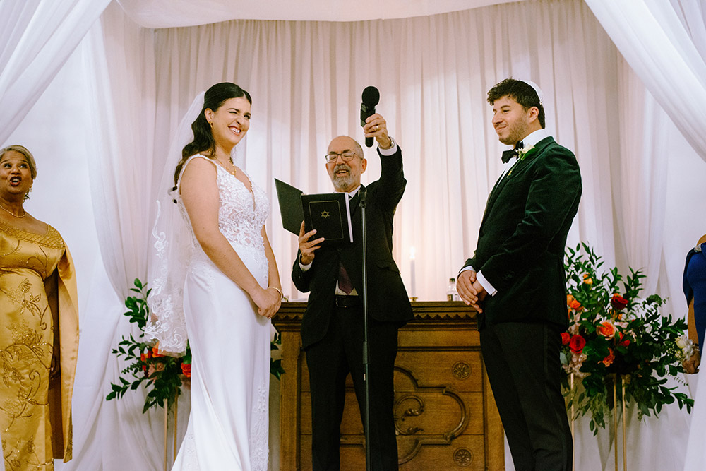bride smiles and winks during the ceremony at The Doctor's House Wedding